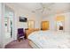 A well-lit bedroom featuring a TV, dresser, chair, and a glimpse into an adjacent bathroom at 10523 Old Grove Cir, Bradenton, FL 34212