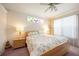 Comfortable bedroom with floral bedding, a decorative window, and warm, inviting lighting at 10523 Old Grove Cir, Bradenton, FL 34212