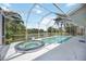 Screened pool and hot tub overlooking a serene lake with lush tropical foliage at 10523 Old Grove Cir, Bradenton, FL 34212