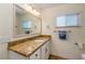 Bright bathroom featuring a granite countertop, framed mirror, and updated fixtures at 112 Palm Ave, Anna Maria, FL 34216