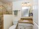 The bathroom features a stone tiled walk-in shower, single sink vanity and a large mirror at 112 Palm Ave, Anna Maria, FL 34216