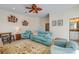 Cozy living room with a ceiling fan, blue furniture set, and decorative fish art pieces on the wall at 112 Palm Ave, Anna Maria, FL 34216