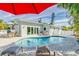 Relaxing backyard with a kidney-shaped pool, patio seating, and lush landscaping for outdoor enjoyment at 112 Palm Ave, Anna Maria, FL 34216