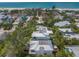 Aerial view of a beautiful home with a swimming pool surrounded by lush tropical trees and landscaping at 120 White Ave, Anna Maria, FL 34216