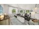 Comfortable living room with a sectional couch, side table, large rug, and floor to ceiling bright windows at 120 White Ave, Anna Maria, FL 34216