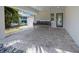 Back patio featuring a swinging couch, gray pavers, and patterned walls at 120 White Ave, Anna Maria, FL 34216