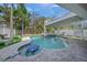 A beautiful in-ground pool and spa surrounded by lush landscaping and stylish pavers at 120 White Ave, Anna Maria, FL 34216