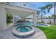Inviting pool and spa featuring stone pavers, tropical landscaping and an outdoor dining area at 120 White Ave, Anna Maria, FL 34216
