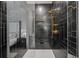Modern shower with sleek black tile, gold fixtures, and a glass door, combining style and functionality at 120 White Ave, Anna Maria, FL 34216