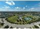 Aerial view of community amenities, including tennis courts, a sports field, splash pad, and playground at 12149 Forest Park Cir, Bradenton, FL 34211
