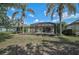 Lovely backyard view featuring a screen enclosed lanai and tropical landscaping at 12149 Forest Park Cir, Bradenton, FL 34211
