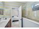 Charming bathroom featuring blue and yellow striped walls, tiled shower, vanity, and view into bedroom at 12149 Forest Park Cir, Bradenton, FL 34211