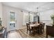 Elegant dining room with stylish chandelier, wood floors, and ample natural light from door and window at 12149 Forest Park Cir, Bradenton, FL 34211