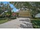 Inviting home featuring a two-car garage, landscaped yard, and mature trees on a sunny day at 12149 Forest Park Cir, Bradenton, FL 34211