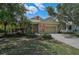 Charming single-story home featuring a manicured lawn, mature trees, and an attached two-car garage at 12149 Forest Park Cir, Bradenton, FL 34211