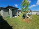 Backyard with a covered porch, a playground, a small tree and a lush green lawn at 13156 Merlot Sunstone Cv, Parrish, FL 34219