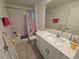 Bright bathroom with tile flooring, a shower over tub and a vanity with ample storage at 13156 Merlot Sunstone Cv, Parrish, FL 34219