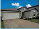 Inviting home exterior featuring a two-car garage, well-maintained lawn, and a tidy landscape at 13156 Merlot Sunstone Cv, Parrish, FL 34219