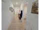 Hallway with tiled flooring, featuring recessed lighting and artwork, leading to various rooms at 13156 Merlot Sunstone Cv, Parrish, FL 34219