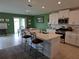 Modern kitchen with white cabinets, stainless steel appliances, a large island and an adjacent dining area at 13156 Merlot Sunstone Cv, Parrish, FL 34219