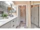 The bathroom is updated with a white vanity, modern fixtures, stylish mirrors, and gray plank accent wall at 1322 Perico Point Cir, Bradenton, FL 34209