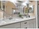 Updated bathroom featuring dual sinks, modern fixtures, a granite countertop, and stylish lighting at 1322 Perico Point Cir, Bradenton, FL 34209