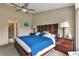 Comfortable bedroom featuring stylish wooden furniture, a ceiling fan, and a doorway to the ensuite bathroom at 1322 Perico Point Cir, Bradenton, FL 34209