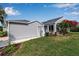 Exterior view of a well-maintained home with light gray siding, a manicured lawn, and landscaped flowerbeds at 1322 Perico Point Cir, Bradenton, FL 34209
