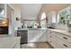 Bright kitchen featuring white countertops, white cabinetry, stainless dishwasher, and wood-look flooring at 1322 Perico Point Cir, Bradenton, FL 34209