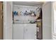 Convenient laundry room with washer, dryer, and storage shelves inside a closet with bifold doors at 1322 Perico Point Cir, Bradenton, FL 34209