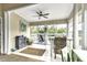 Bright sunroom with tile floors, ceiling fan, large windows, and access to a deck overlooking a lush green space at 1322 Perico Point Cir, Bradenton, FL 34209