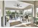 Bright sunroom with tile floors, ceiling fan, large windows, and access to a deck overlooking a lush green space at 1322 Perico Point Cir, Bradenton, FL 34209