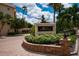 Welcome to Fiesta Harbor: a charming entrance amidst colorful flowers and lush greenery at 1350 N Portofino Dr # 208, Sarasota, FL 34242