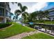 Waterfront condo exterior with boat dock, lush tropical landscaping and access to the water at 1350 N Portofino Dr # 208, Sarasota, FL 34242