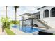 A Luxurious pool with waterfall feature and palm trees, adjacent to an outdoor dining area on the upper level at 1384 Harbor Dr, Sarasota, FL 34239