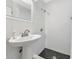 Modern bathroom featuring a pedestal sink, walk-in shower with black hexagon tiles and white subway tile walls at 170 Roosevelt Dr # 2, Sarasota, FL 34236