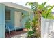 Inviting front door with red brick tile, a chair, and vibrant tropical landscaping at 170 Roosevelt Dr # 2, Sarasota, FL 34236