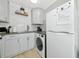 Well-lit kitchenette features sleek gray counters, white cabinets, modern appliances, and a combination washer/dryer at 170 Roosevelt Dr # 2, Sarasota, FL 34236