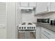 Efficient white kitchenette features modern appliances, ample counter space, and overhead ventilation for cooking convenience at 170 Roosevelt Dr # 2, Sarasota, FL 34236