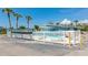 Community pool with white fence and lounge furniture offers an inviting space to relax and enjoy the sun at 170 Roosevelt Dr # 2, Sarasota, FL 34236