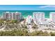 Aerial view of the condo complex surrounded by palm trees and other buildings at 1770 Benjamin Franklin Dr # 407, Sarasota, FL 34236
