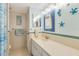 Bright bathroom featuring a vanity, tiled wall accents and decorative marine life at 1770 Benjamin Franklin Dr # 407, Sarasota, FL 34236