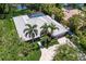 An overhead view of a home featuring a screened pool, tile roof, palm trees and verdant landscaping at 1780 Pine Harrier Cir, Sarasota, FL 34231