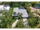 Aerial view of home with tile roof, screened pool, palm trees and meticulous landscaping near a pond at 1780 Pine Harrier Cir, Sarasota, FL 34231