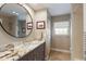 Well-lit bathroom with an extended stone countertop vanity and decorative framed mirror at 1780 Pine Harrier Cir, Sarasota, FL 34231