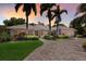 Stunning home showcasing palm trees, meticulous landscaping, and a paver driveway, set against a colorful sunset sky at 1780 Pine Harrier Cir, Sarasota, FL 34231