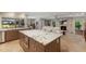 Spacious kitchen featuring granite countertops, a large island, stainless steel appliances, and an open view to the living area at 1780 Pine Harrier Cir, Sarasota, FL 34231