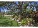 Expansive backyard featuring lush landscaping, a mature tree, and meticulously maintained lawn, creating a serene outdoor retreat at 1780 Pine Harrier Cir, Sarasota, FL 34231