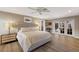 Spacious main bedroom featuring a large bed, French doors to the lanai, and en-suite bathroom at 1780 Pine Harrier Cir, Sarasota, FL 34231