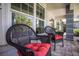 Inviting covered patio with wicker chairs, red cushions, and views of the lush, tropical landscaping at 1780 Pine Harrier Cir, Sarasota, FL 34231